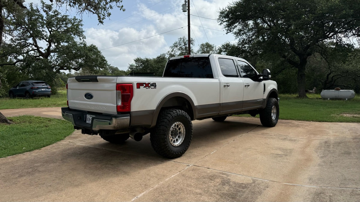 Dylan’s personal white and tan Ford 6.7 Power Stroke, shown from the rear.