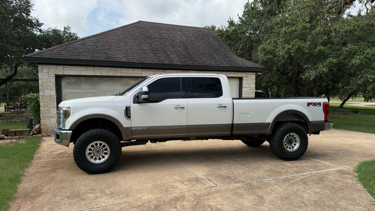 Dylan’s personal white and tan Ford 6.7 Power Stroke, shown from the side.